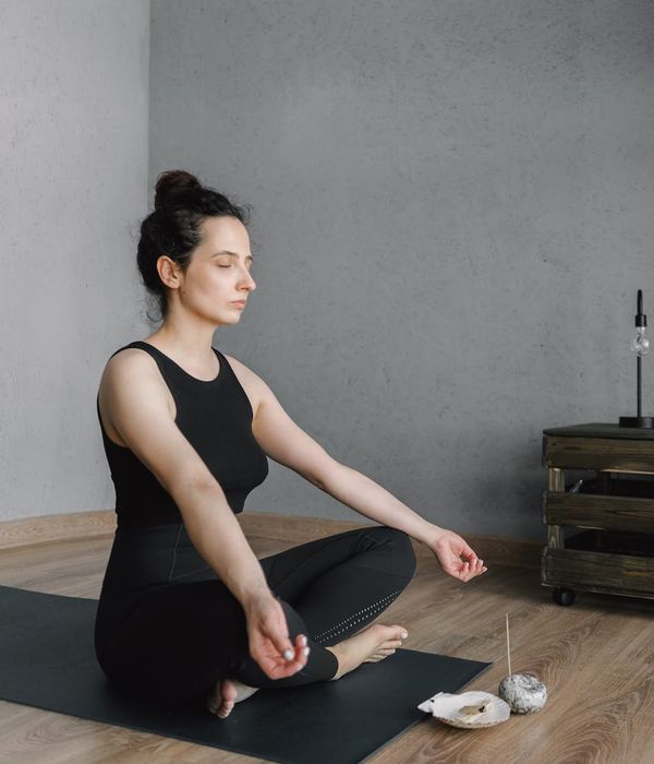 Person meditating peacefully in a calm, minimalist room.