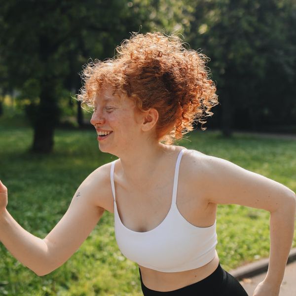 Woman feeling energetic and happy outdoors in the morning sun.